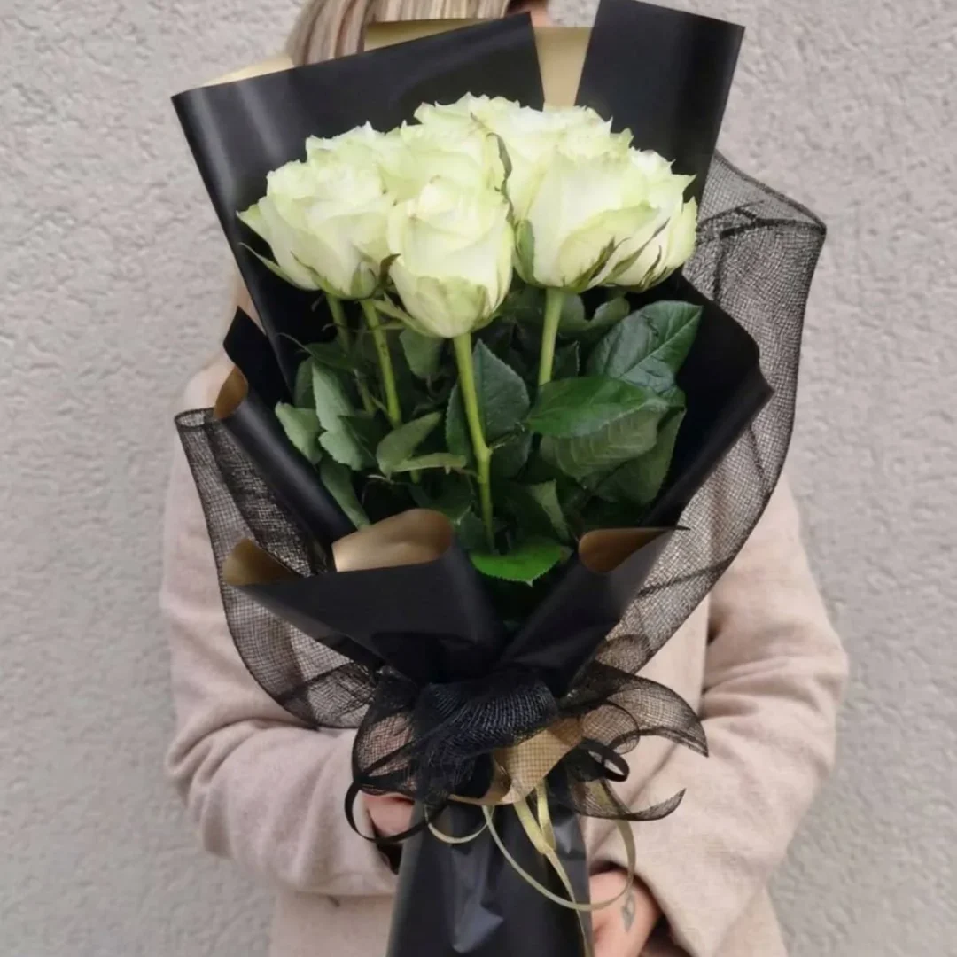 Baltų rožių puokštė apipavidalinta juodu popieriumi, skirta išreikšti užuojautą netekties akimirką