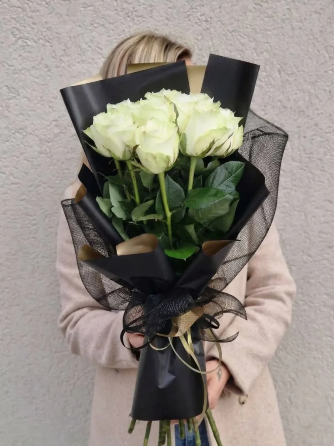 Baltų rožių puokštė apipavidalinta juodu popieriumi, skirta išreikšti užuojautą netekties akimirką